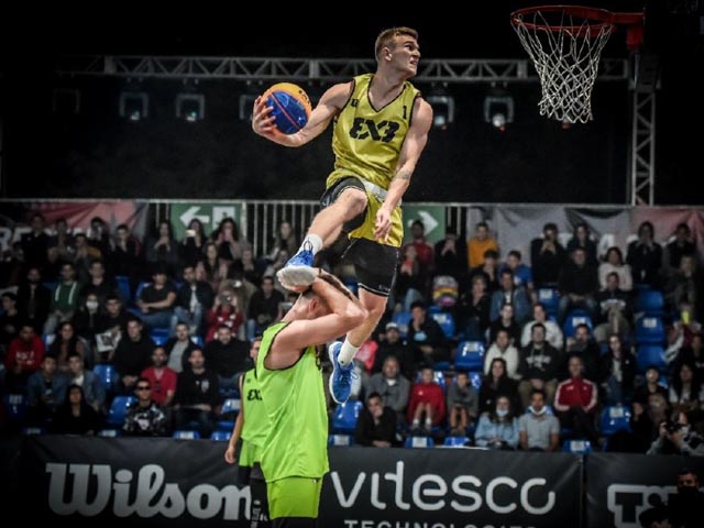 FIBA player leaping towards basket while being guarded